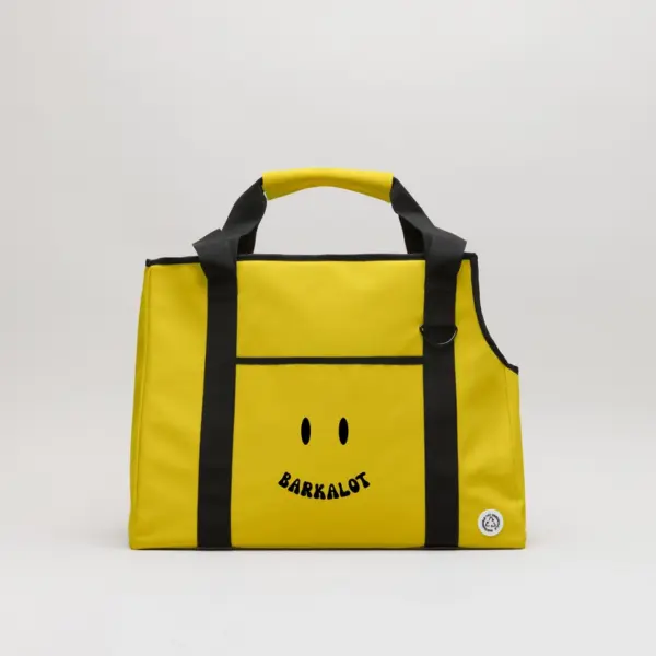 Borsa trasportino per cani in pvc riutilizzato e impermeabile gialla con manico e con sopra stampato uno smile nero.