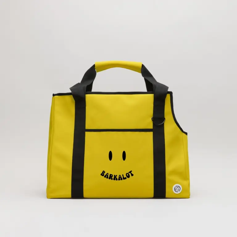 Borsa trasportino per cani in pvc riutilizzato e impermeabile gialla con manico e con sopra stampato uno smile nero.
